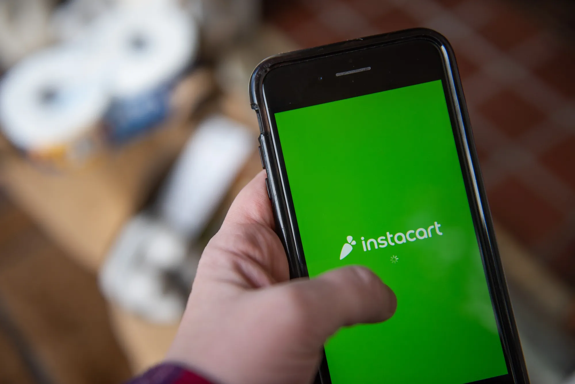 The Instacart logo on a smartphone.