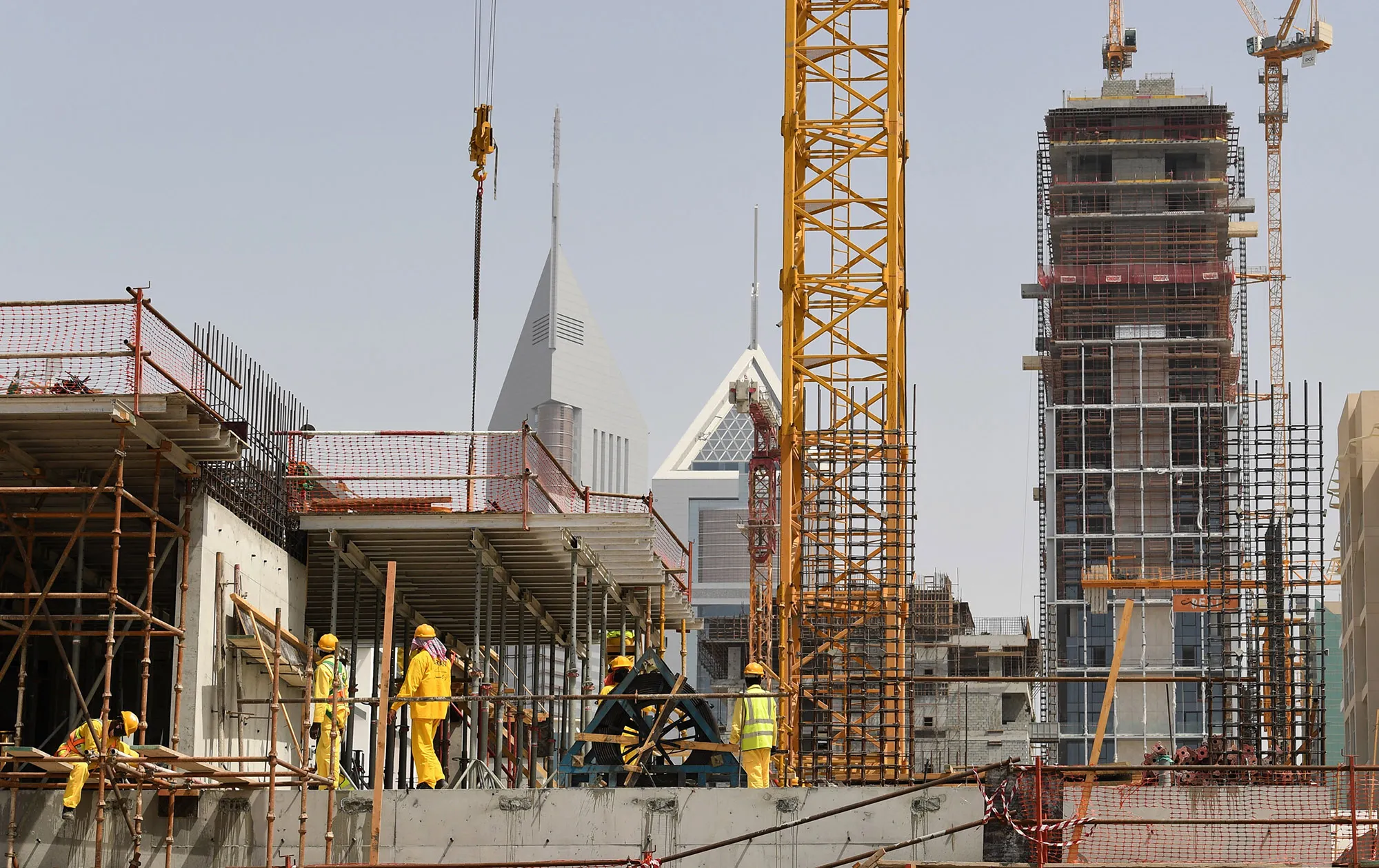 Construction workers stand on a scaffold as they work during a lockdown, in Dubai on April 7.