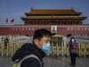A Chinese couple wear masks as they visit the Tiananmen Gate before the Chinese New Year and Spring Festival on Jan. 24, 2020 in Beijing.