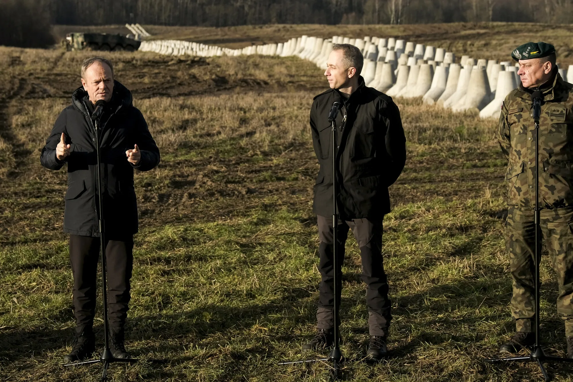 Cezary Tomczyk, center, visits the Polish border defenses in Dabrowka, Poland.