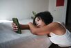 Digital Devices and Mental Health. Upset African American woman looking at smartphone screen feeling sad reading sms message scrolling on social media