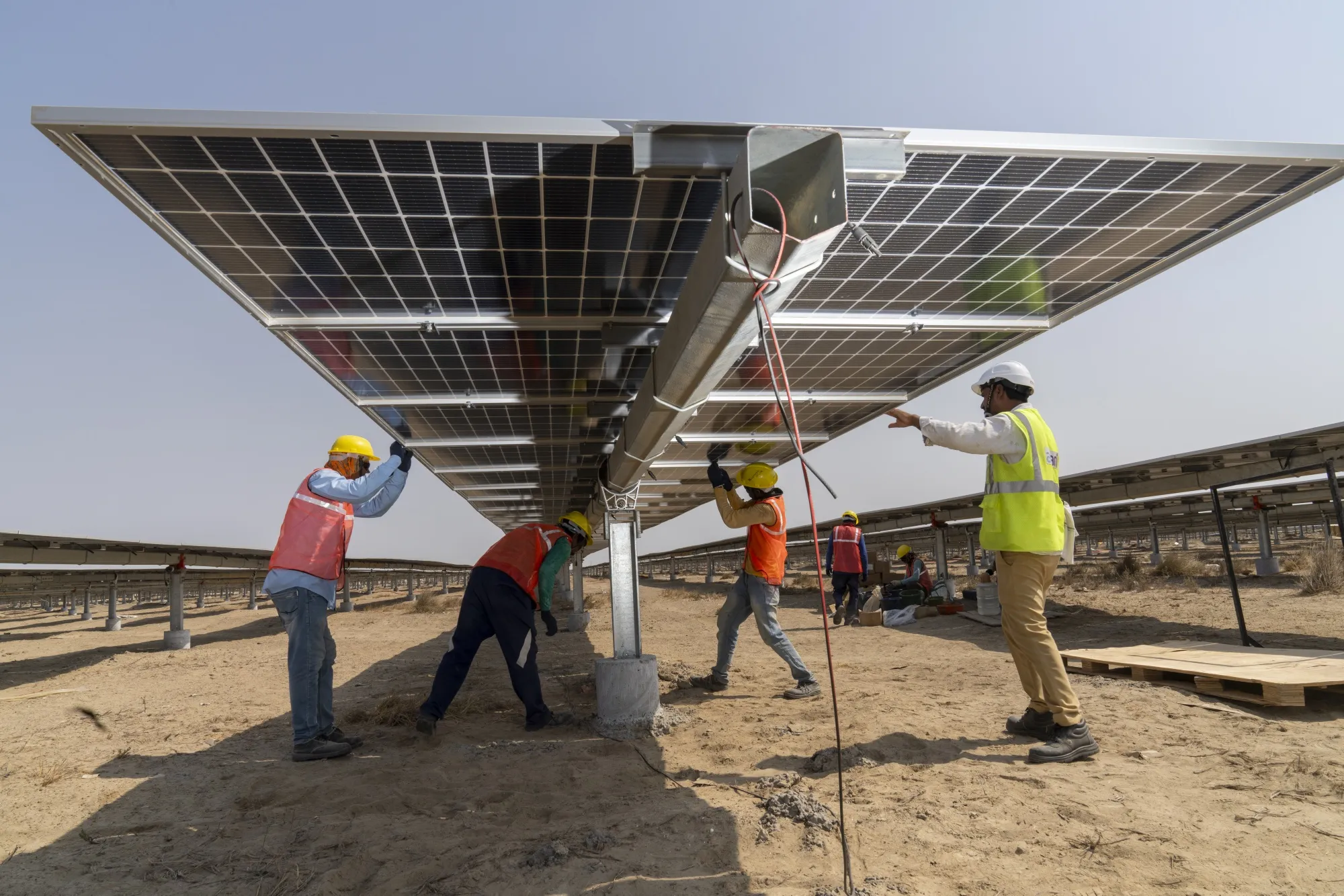 Workers install solar panels at a renewable energy park in Khavda, Gujarat, India.