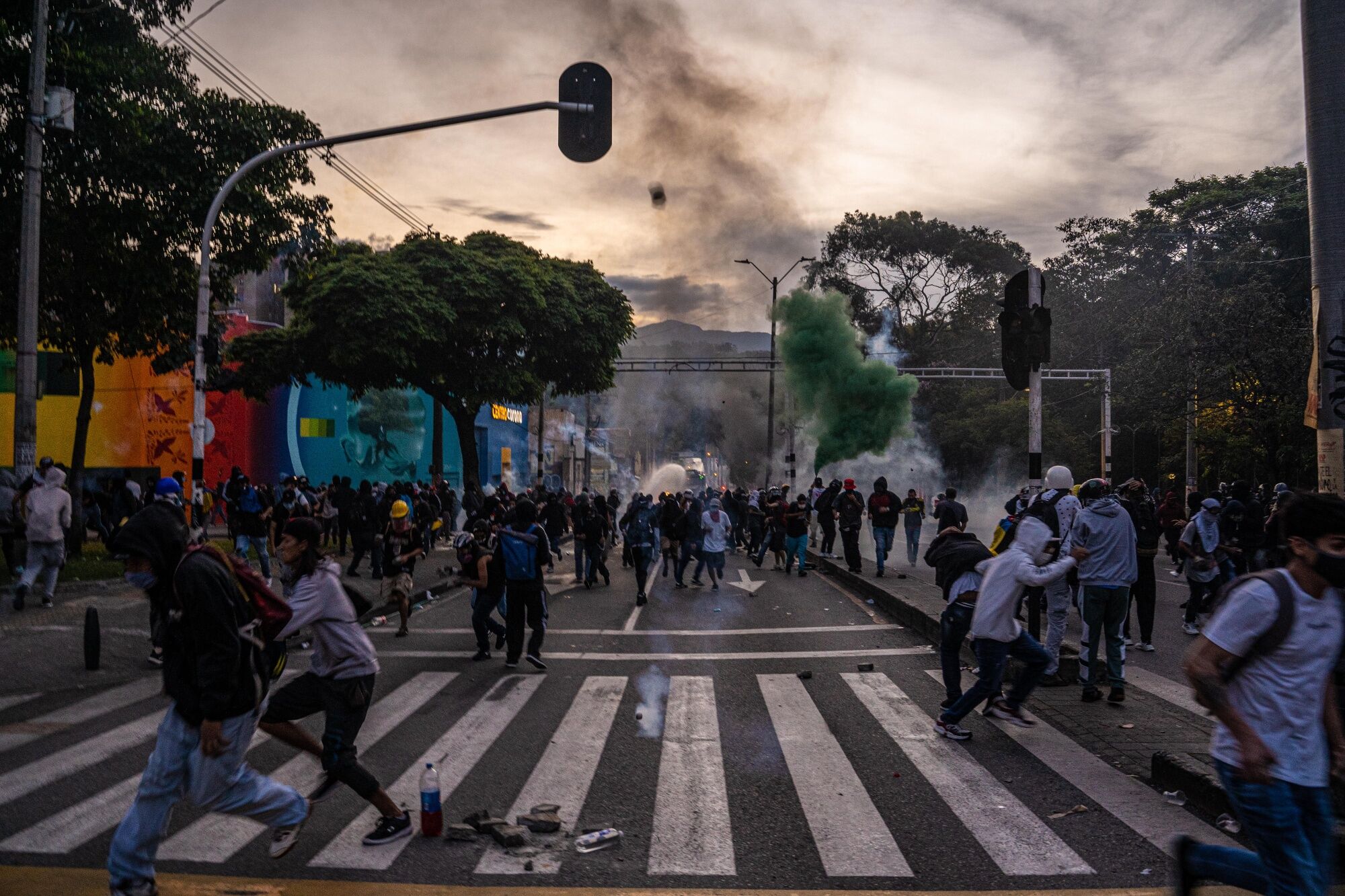 Demonstrators run from tear gas during clashes with police in Medellin, Colombia, on May 22.