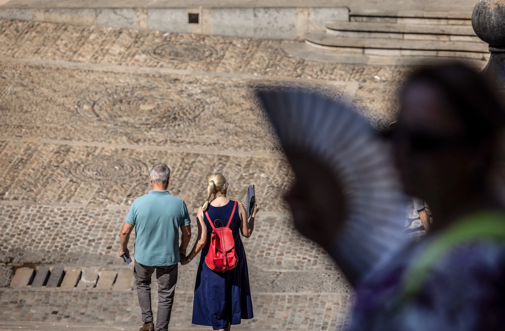 Tourists use hand fans on the steps of the Cathedral of Santa Maria during high temperatures in the old town area of Girona, Spain, on Aug. 23.