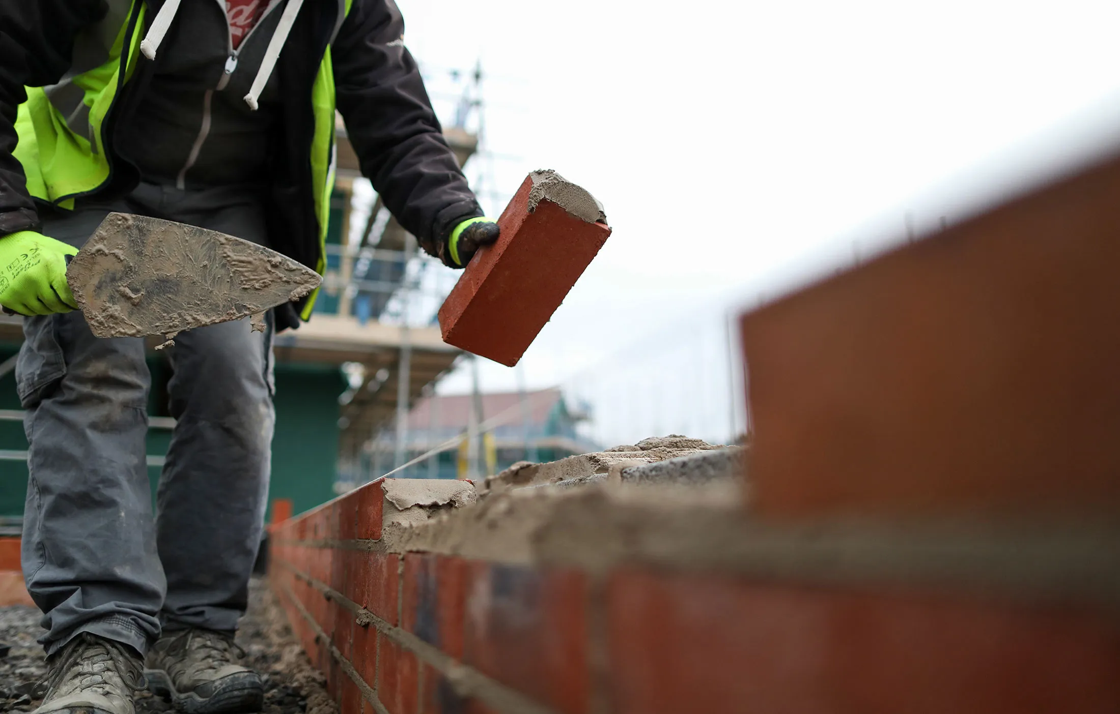 A builder lays bricks at a Persimmon Plc residential property construction site in Weston-Super-Mare, U.K., on Thursday, Jan. 26, 2017. Persimmon -- the U.K.'s largest homebuilder by market value -- designs, develops and builds residential housing units ranging from studio apartments to executive family homes throughout the United Kingdom.
