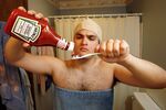 Amateur film maker Dan Burke, at his Dayton, Ohio home, recreates a scene where he brushed his teeth with ketchup for a Heinz ketchup commercial contest on YouTube.