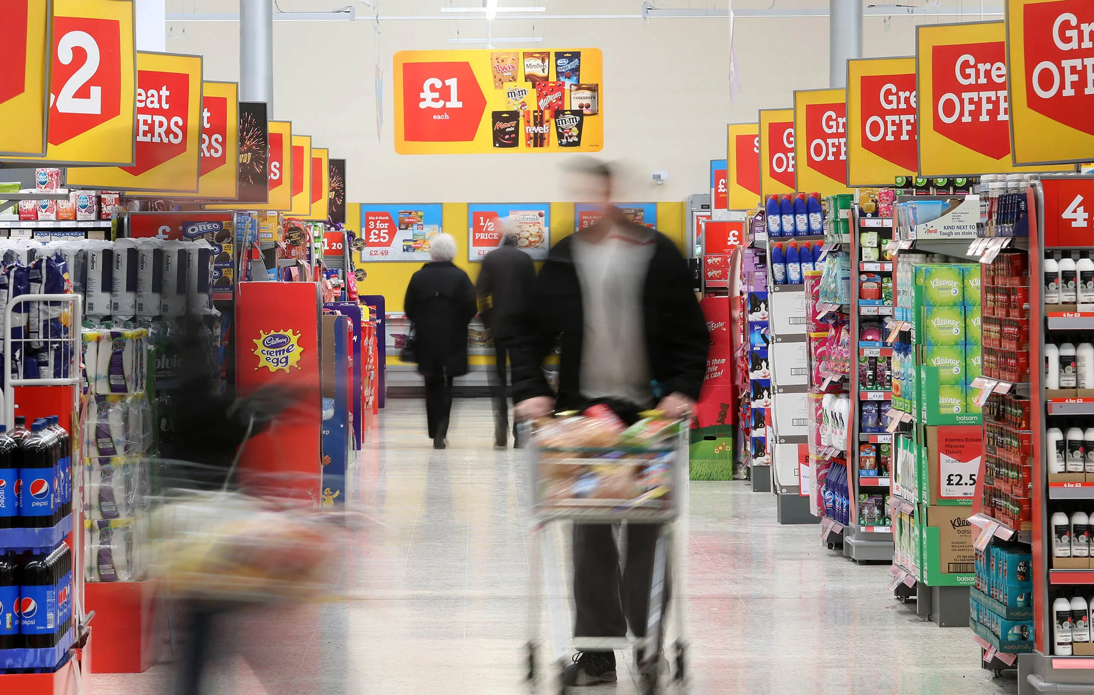 Customers pass along the central aisle inside a Morrisons supermarket, operated by William Morrisons Supermarkets Plc, in Crawley, U.K., on Tuesday, March 3, 2015. Wm Morrison Supermarkets Plc named David Potts as chief executive officer, tasking the former head of Tesco Plc's Asia unit with reviving the ailing British grocer.
