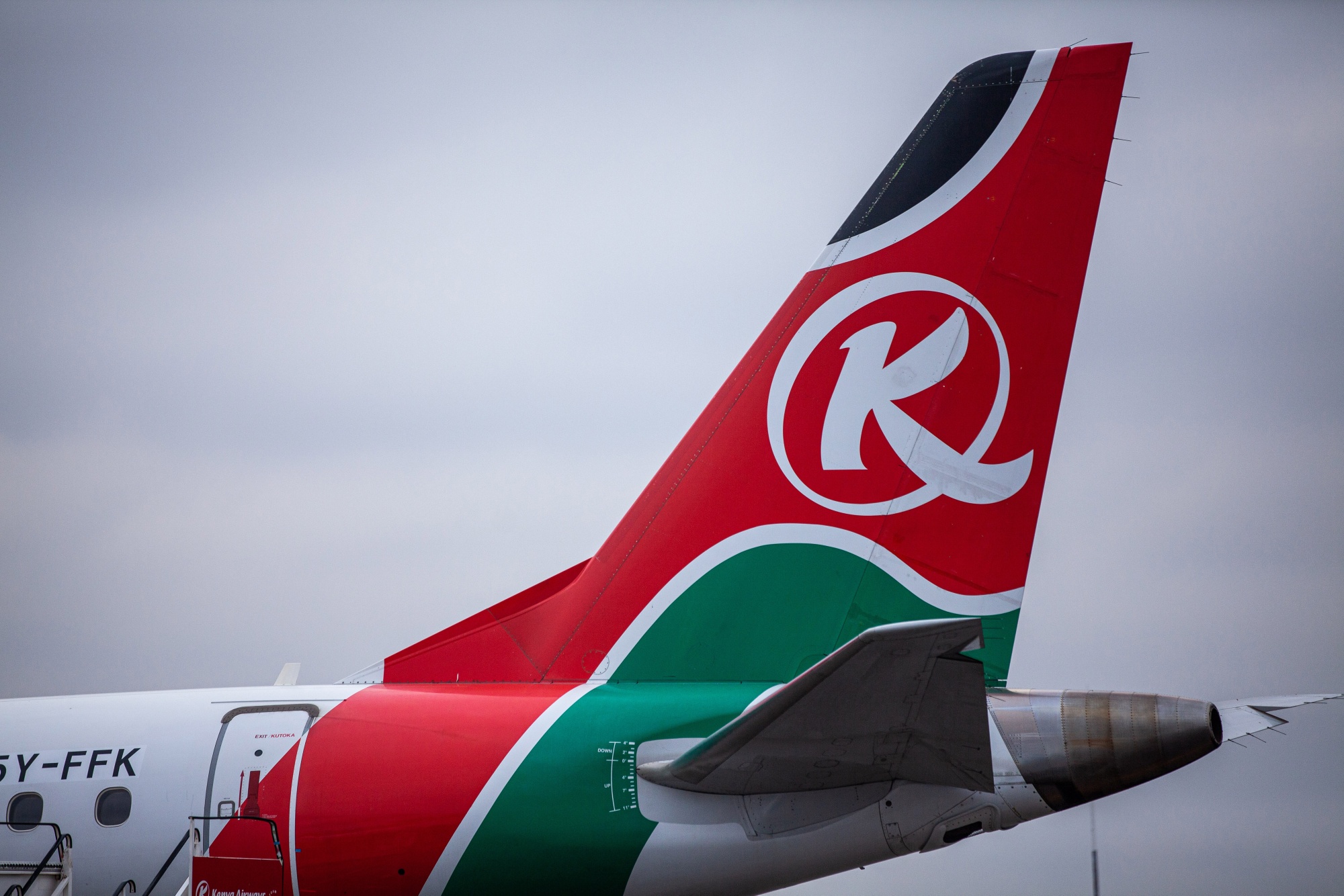 Livery for Kenya Airways Ltd. sits on the tailfins of passenger aircraft on the tarmac at Jomo Kenyatta International Airport in Nairobi, Kenya, on Wednesday, July 15, 2020. Kenya Airways Plc started a three-month round of job cuts as lawmakers debate a bill to nationalize the carrier and its losses mount due to the impact of the coronavirus pandemic. Photographer: Patrick Meinhardt/Bloomberg