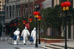Volunteers in isolation gowns walk to send groceries to residents in home quarantine in Wuhan on Feb. 20.