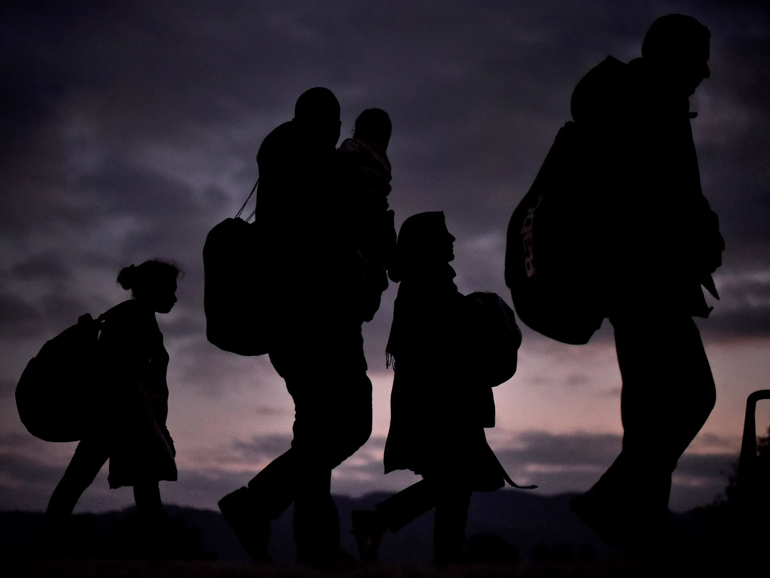 Migrants walk from the village of Rigonce to Brezice refugee camp in tha dark on October 23, 2015 in Rigonce, Slovenia.