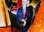Attendees take pictures with a cardboard cutout of Warren Buffett during the Berkshire Hathaway annual meeting.