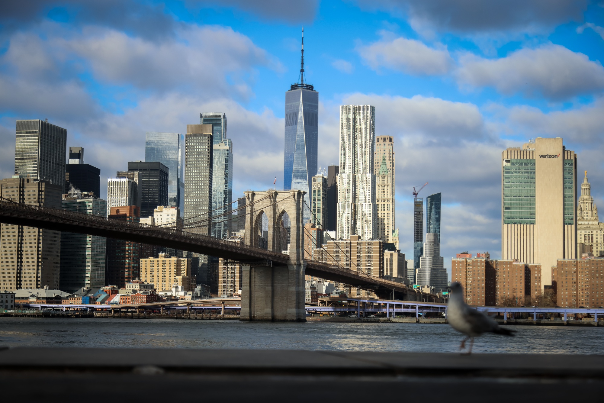 The Brooklyn Bridge and One World Trade Center along the Manhattan skyline in New York, US, on Tuesday, Dec. 30, 2025. New York City is staring down a $10 billion budget gap next fiscal year, reflecting slowing tax collections and uncertainty over federal funding streams. Photographer: Michael Nagle/Bloomberg
