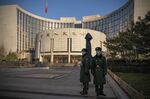 People's Liberation Army soldiers stand in front of the People's Bank of China in Beijing, China.