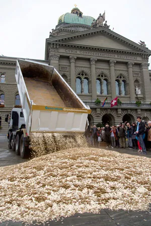 Activists dump a truckload of 8 million five-centime coins, one coin for every person living in Switzerland, in front of the parliament building in Bern on Oct. 4