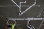 A plumber installs pipe in a building in Washington, D.C.