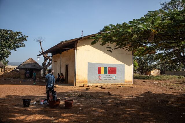 In Damaro, where villagers say water systems have been polluted, a painted sign promotes a Chinese initiative to provide satellite TV access to 10,000 African villages.