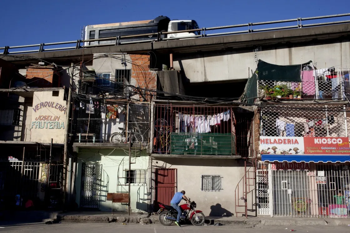 A vehicle drives on a highway over apartments in the Villa 31 neighborhood of Buenos Aires.
