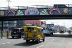 A jeepney&nbsp;travels under a bridge with a mural thanking front-line workers in Pampanga.