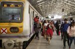 Commuters disembark from a train as others walk along a platform during the morning rush hour at Churchgate Station near the financial district of Mumbai, India, on Friday, April 4, 2014. The biggest election in world history starts April 7 in the Himalayan foothills of northeastern India, with Narendra Modi's opposition party poised to win the most seats as it looks to regain power after a decade.