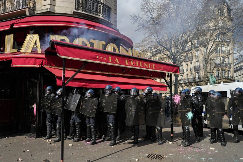 French Unions Renew Strikes to Push Macron Into Pension U-TurnRiot police take cover from paint bombs and projectiles behind protective shields outside La Rotonde restaurant in central Paris, France, on Thursday, April 6, 2023. 