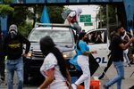 A group of demonstrators take over a police car during a protest over the high cost of food and gasoline in Panama City, on July 11.