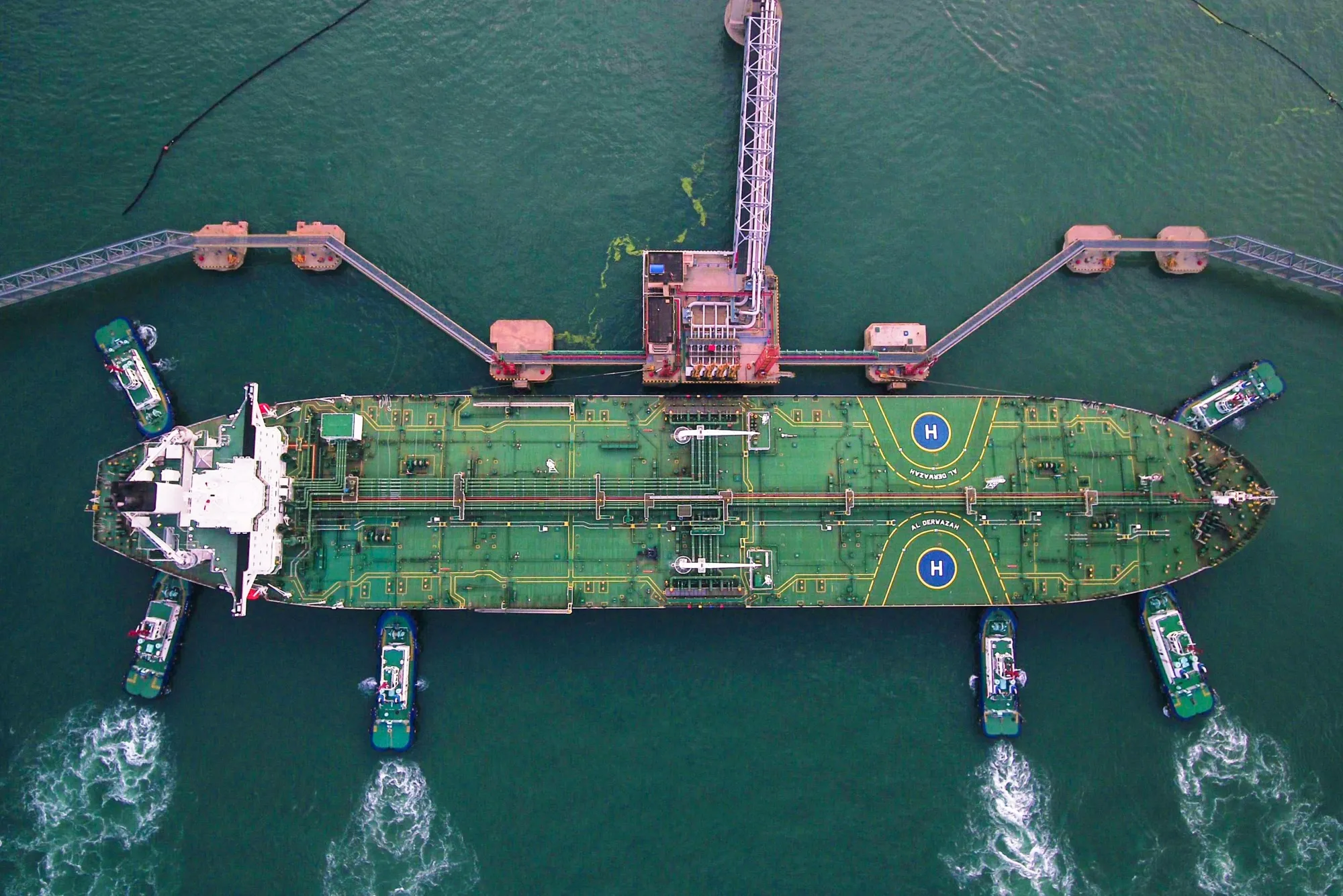 Tugboats move an oil tanker at Qingdao port in Qingdao, China.