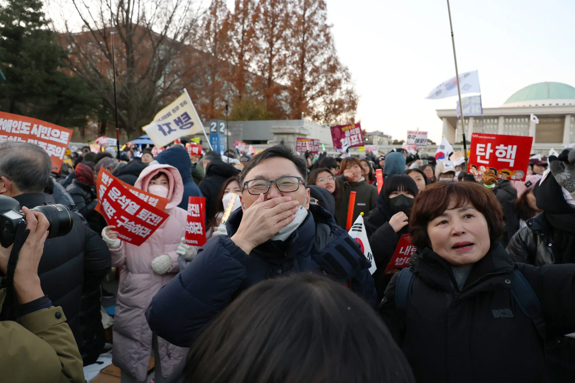 Demonstrators react after lawmakers passed a motion to impeach South Korean President Yoon Suk Yeol.