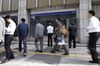 Pedestrians, center, look at an electronic stock board while other people walk by outside a securities firm in Tokyo, Japan, on Wednesday, Oct. 18, 2017. As Prime Minister Shinzo Abe's ruling party heads for what polls suggest will be its best national election result in more than three decades, Japan's stock market has surged to heights not seen since before the financial crisis.