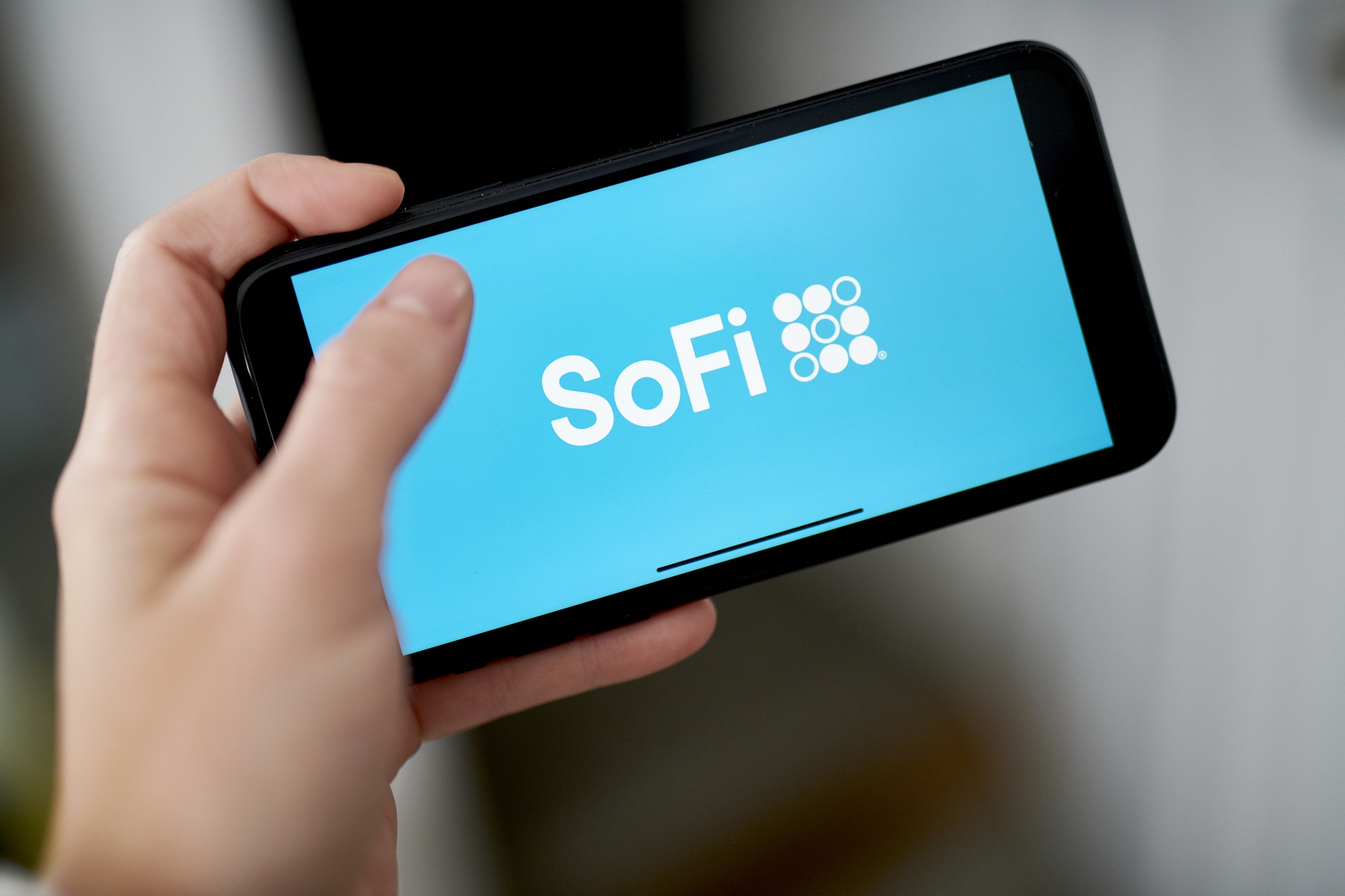 The logo for SoFi on a smartphone.