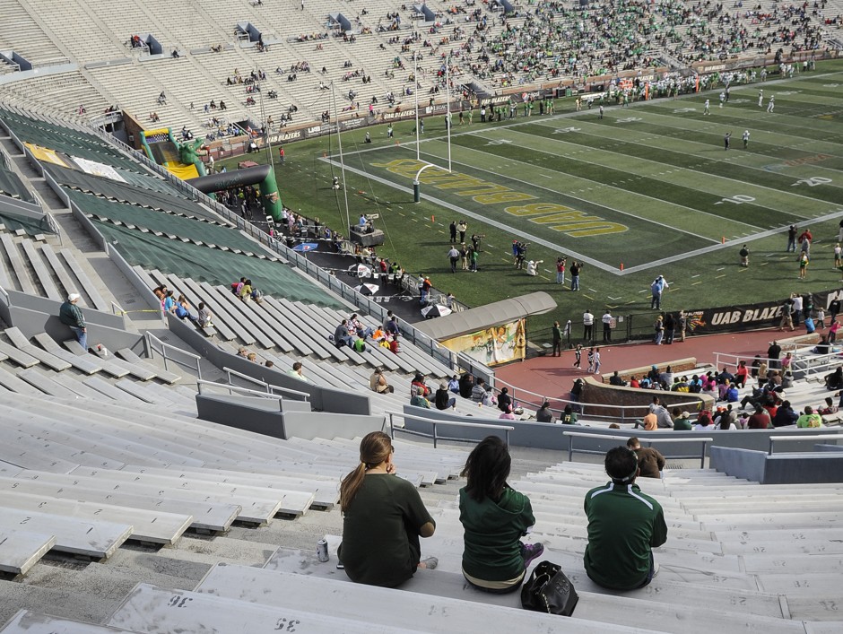 A trio of UAB fans watch one of the school's final football games.