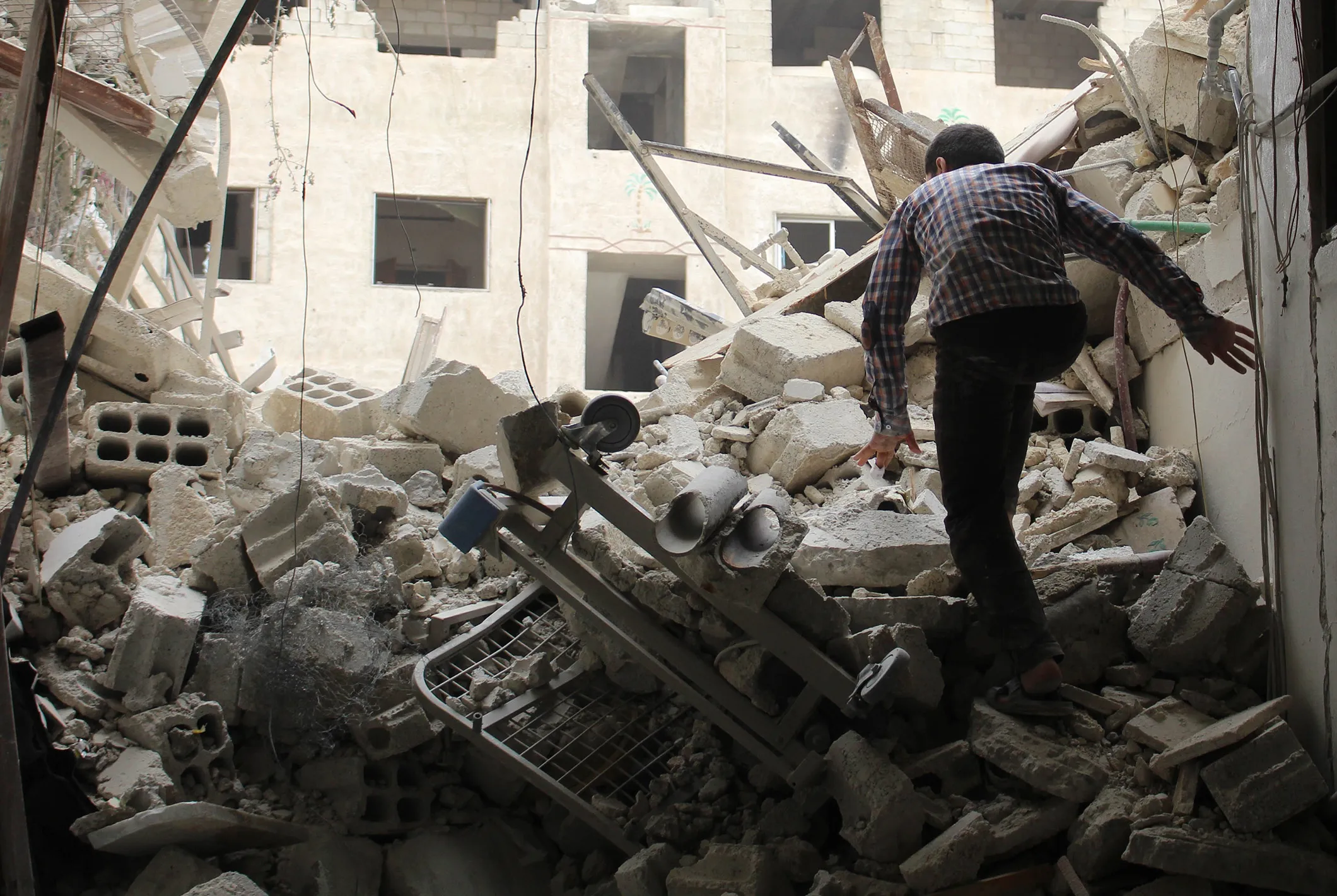 A Syrian man inspects the wreckage of a collapsed hospital after an airstrike in Damascus, on May 1, 2017.
