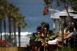 Customers dine outdoors at a restaurant in Manhattan Beach, California, U.S., on Friday, July 3, 2020.