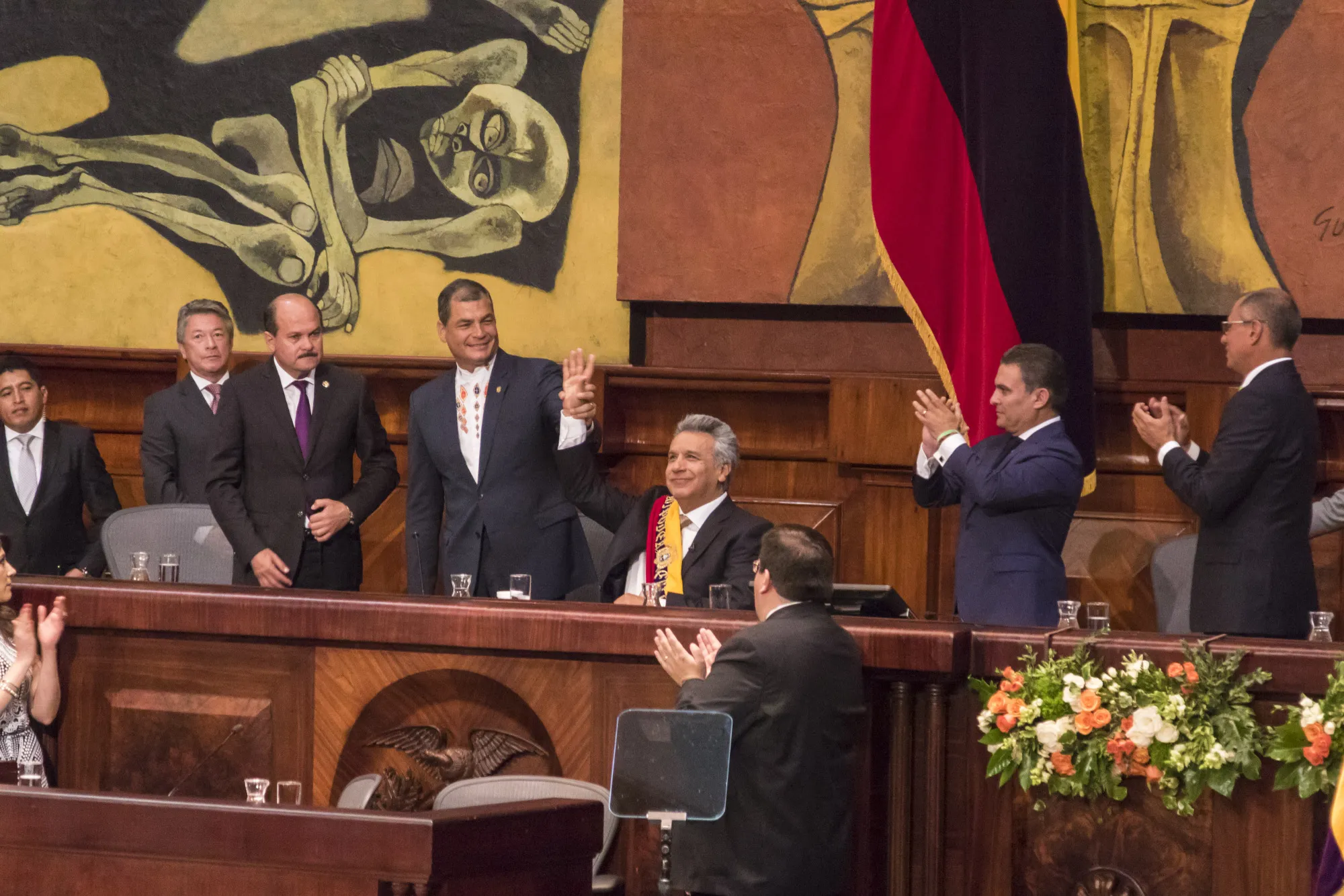 Former president Rafael Correa, center left, raises the hand of Lenin Moreno, center, during the presidential inauguration in May 2017.