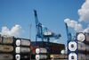 Shipping containers sit stacked in front of a gantry crane at the Port of New Orleans in New Orleans, Louisiana, U.S.