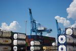 Shipping containers sit stacked in front of a gantry crane at the Port of New Orleans in New Orleans, Louisiana, U.S.