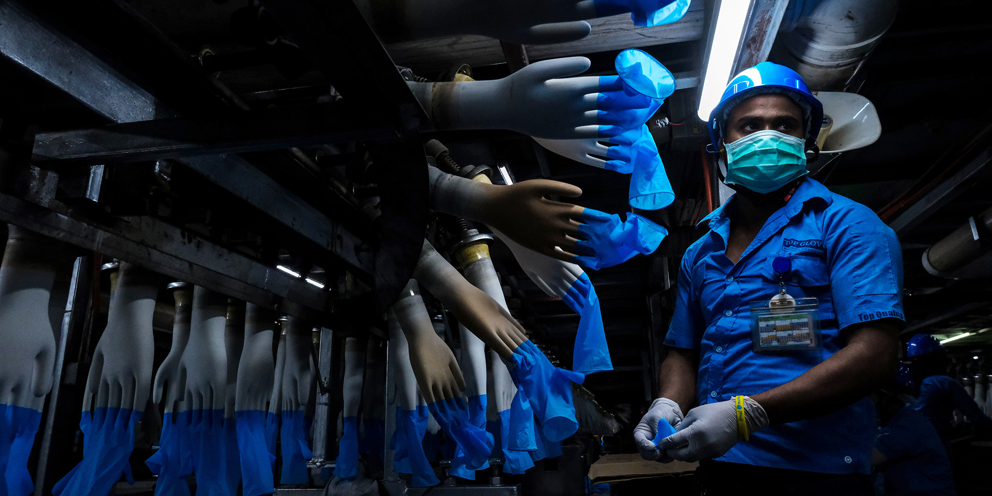 An employee monitors latex gloves on&nbsp;molds&nbsp;at a glove factory in Setia Alam, Selangor, Malaysia, on Feb. 18.