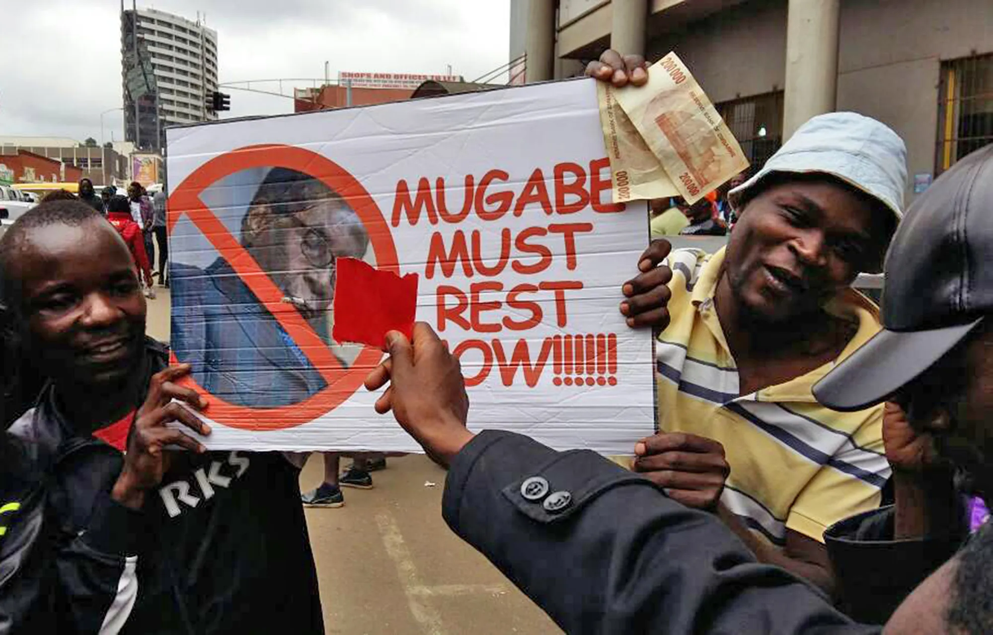 Demonstrators hold a placard reading "Mugabe Must Rest Now!" as they call for the resignation of president Robert Mugabe in Harare on&nbsp;Nov. 18.