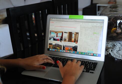 A Cuban woman provides an Airbnb reservation service from a laptop in a rental house in Havana.