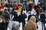 Shoppers wear protective face masks on a crowded retail high street in Frankfurt, Germany, on Monday, Dec. 14, 2020.