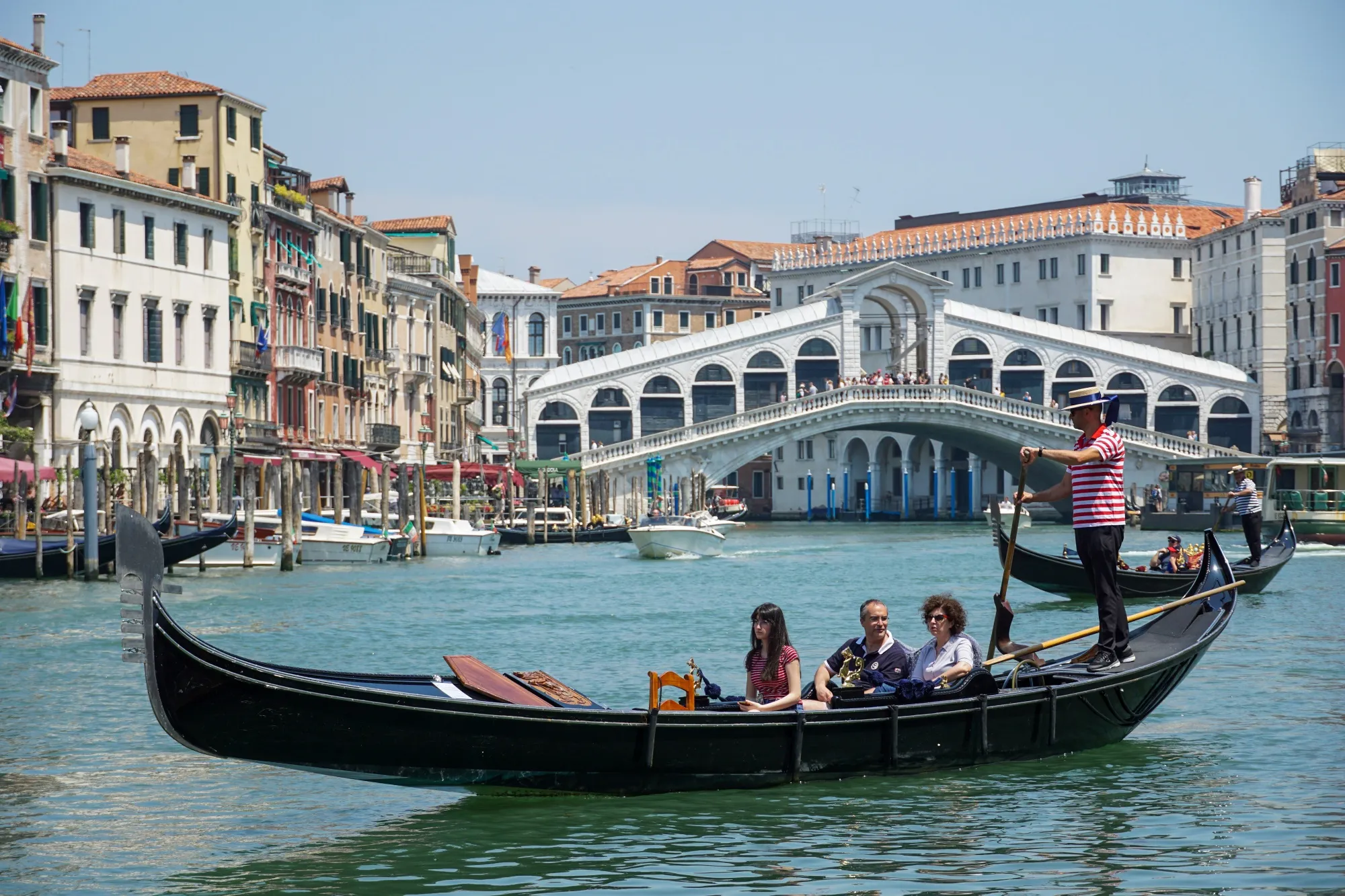 Tourists ride a gondolier in view of the Rialto Bridge on the Grand Canal in Venice.