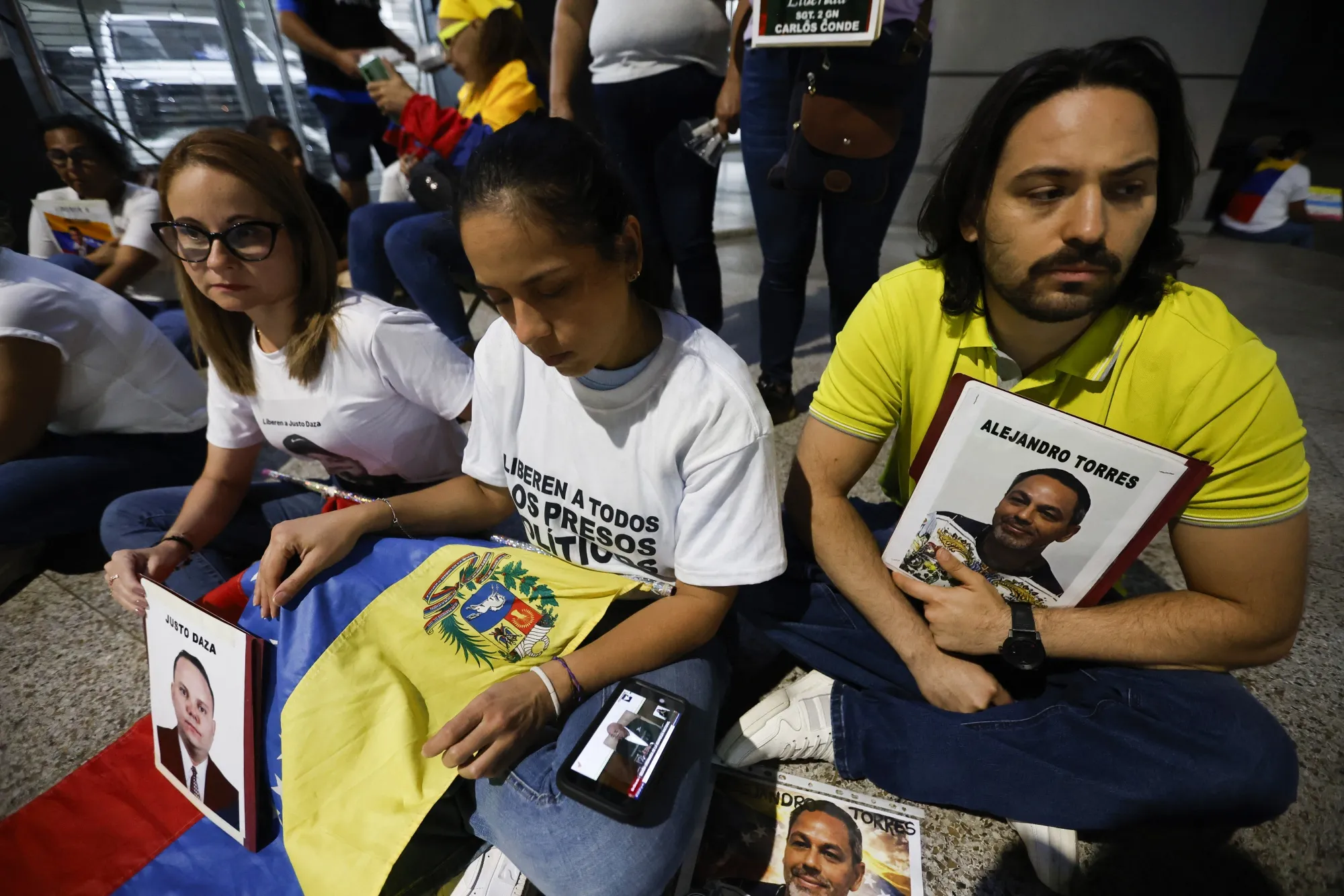Relatives of political prisoners watch the livestream of a debate on an amnesty bill proposed by Venezuela's interim president Delcy Rodriguez, in Caracas on Feb. 19.
