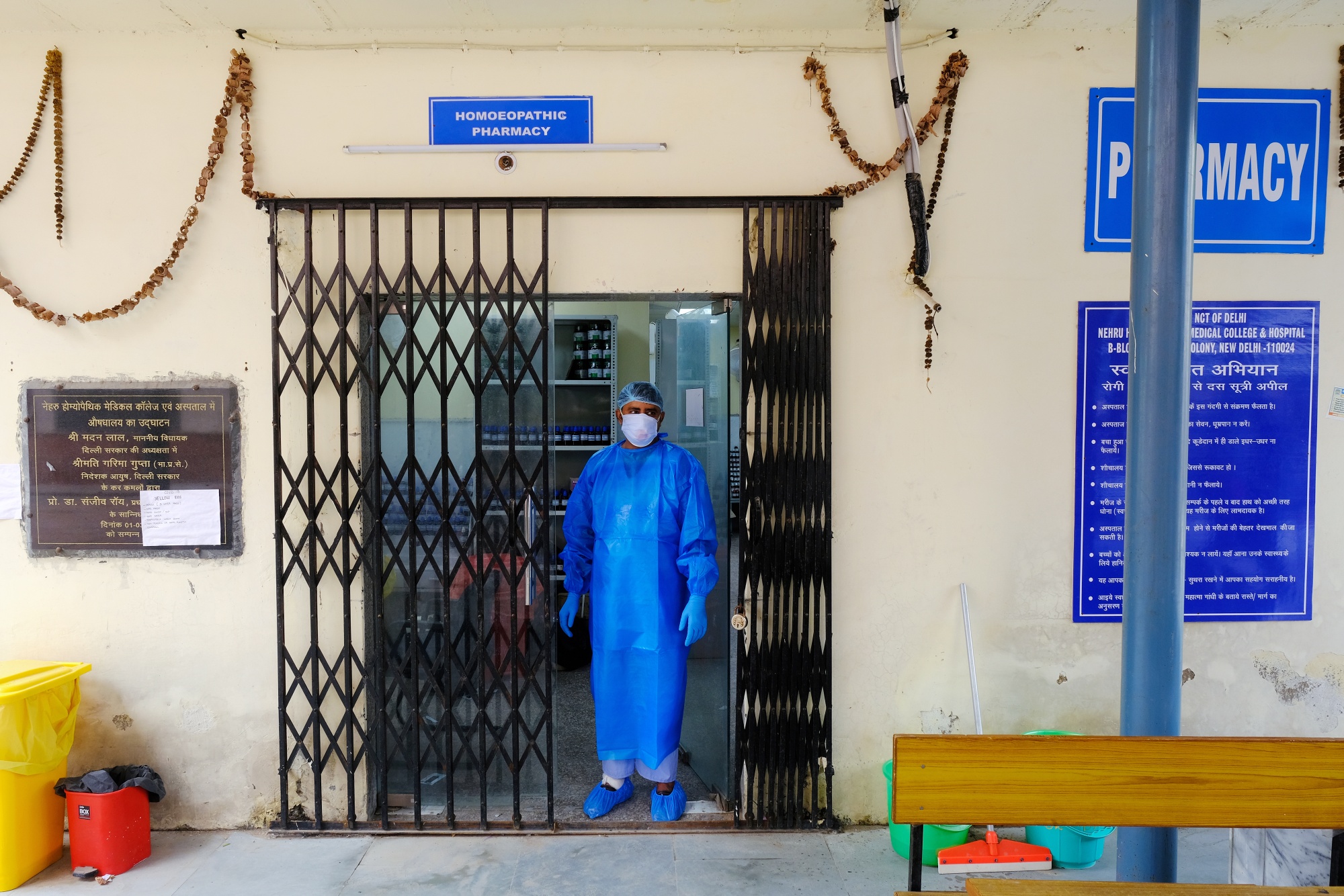 A health worker wearing personal protective equipment stands in a doorway at a rapid-antigen methodology Covid-19 testing center&nbsp;in New Delhi.