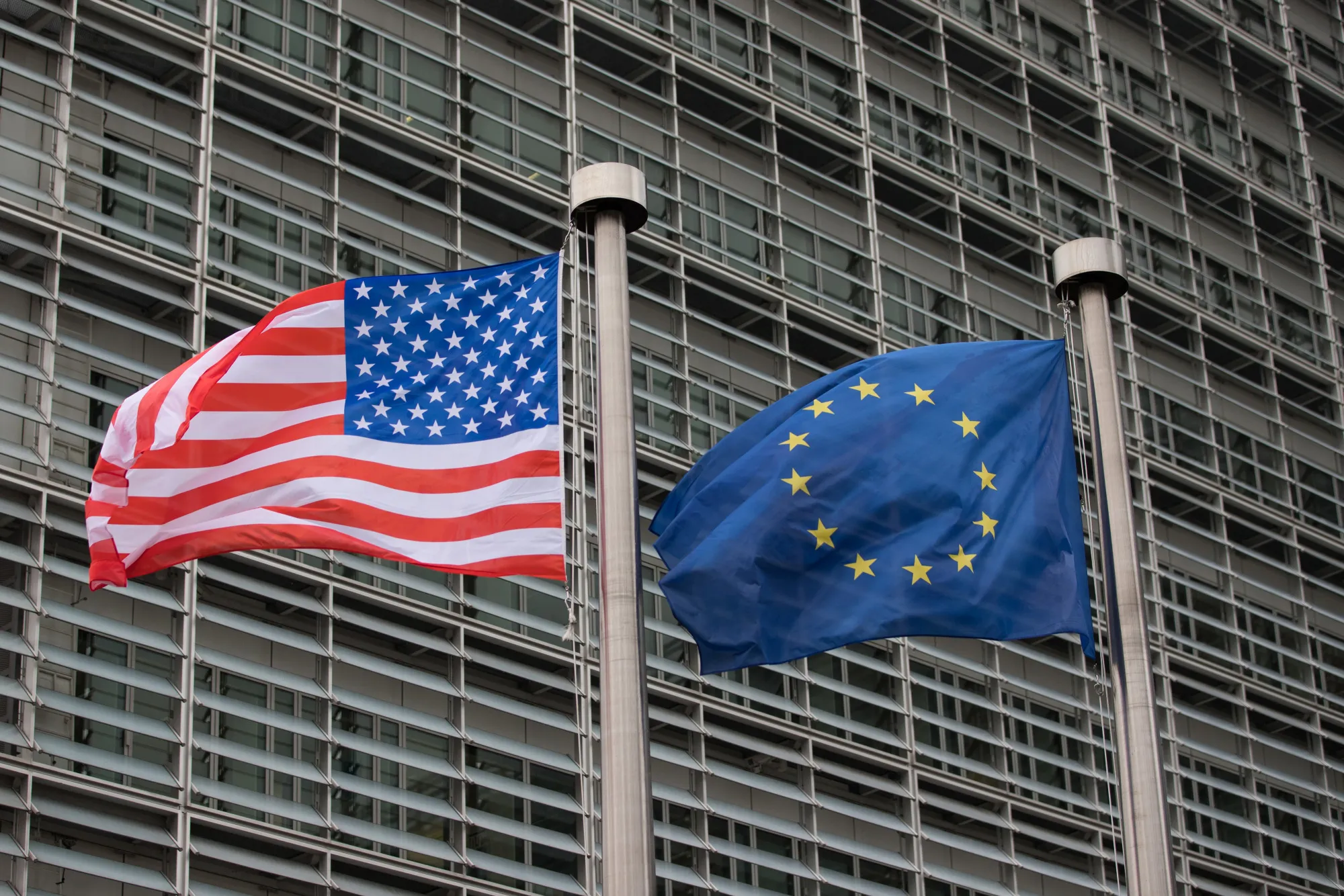 U.S. and EU flags outside a European Commission building in Brussels.