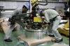 Employees operate machinery to stack coils of aluminum strip for packaging at the Tokiwa Koutai Co. processing plant in Tokyo.