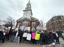 Demonstrators hold signs during a “Hands Off!” protest against President Donald Trump in Portsmouth, New Hampshire, on April 5, 2025.