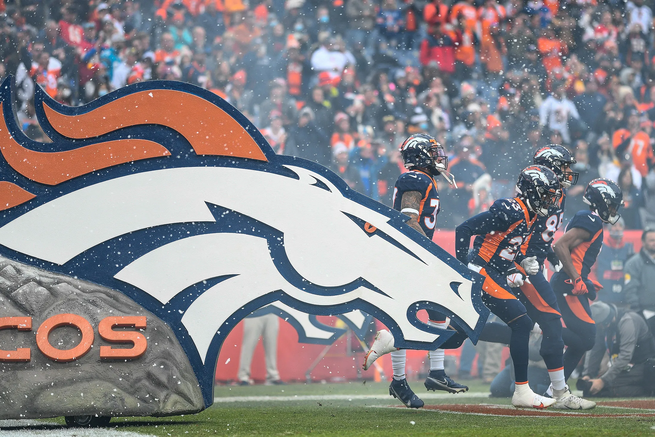 Denver Broncos players run onto the field before a game against the Kansas City Chiefs at Empower Field at Mile High on Jan.&nbsp;8.