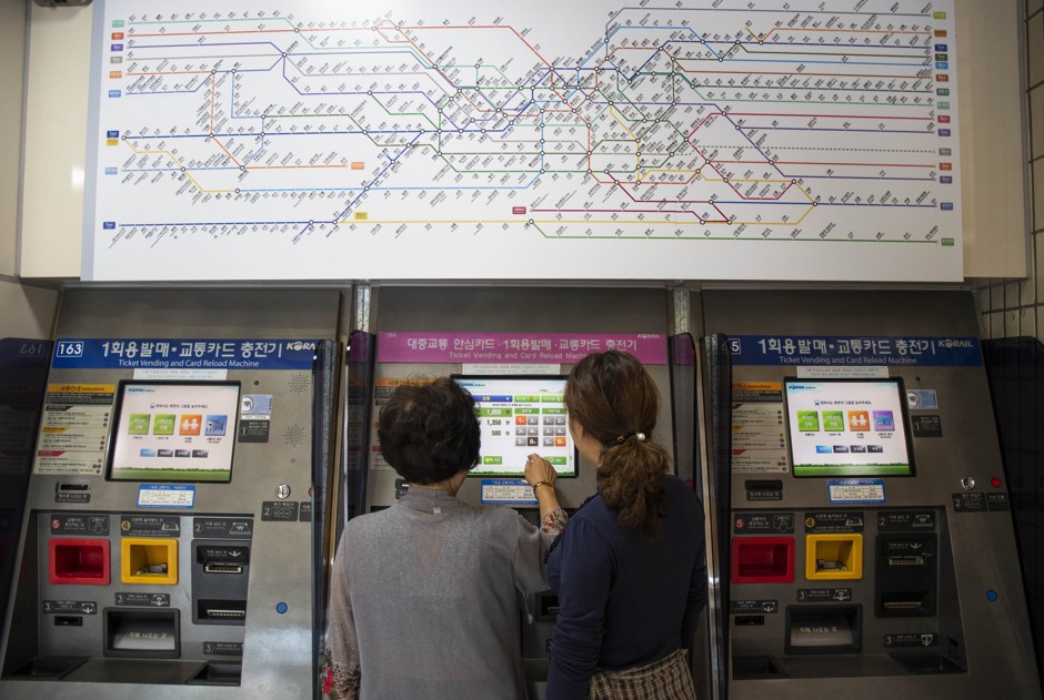 Jung-ae Gwak, left, and her daughter, Hanbyeol Lee, right, get a ticket to ride the Seoul metro. When Lee first arrived in Seoul from North Korea, she says she was bewildered by the fact that people sat directly across from each other instead of all facing the same direction.