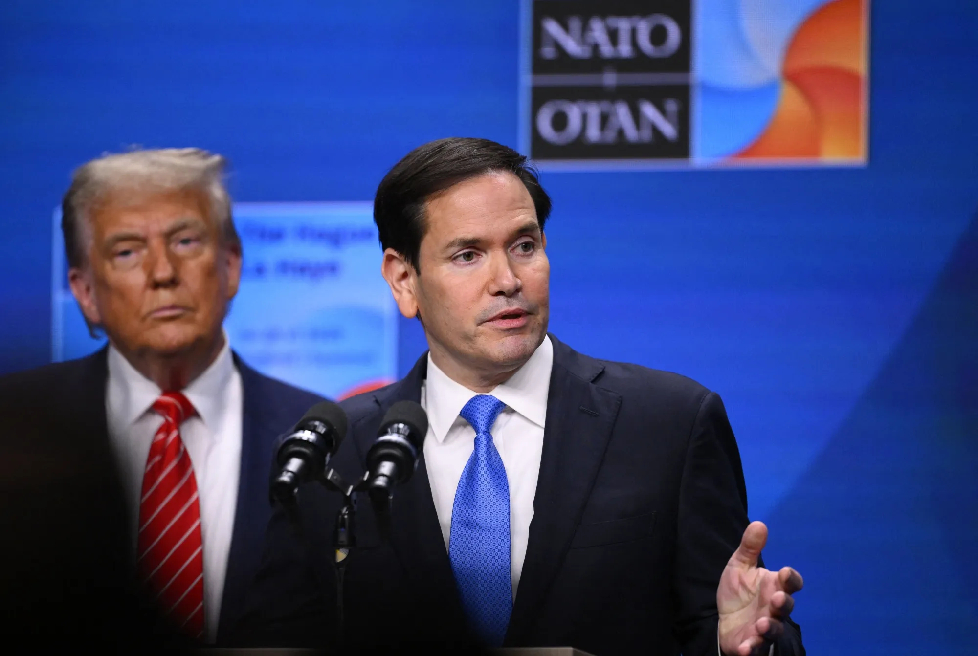 Secretary of State Marco Rubio flanked by&nbsp;President Donald Trump, speaks at a press conference during the NATO summit in The Hague in 2025.