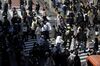 Pedestrians wearing protective masks cross an intersection in Tokyo's Shibuya district on March 26.