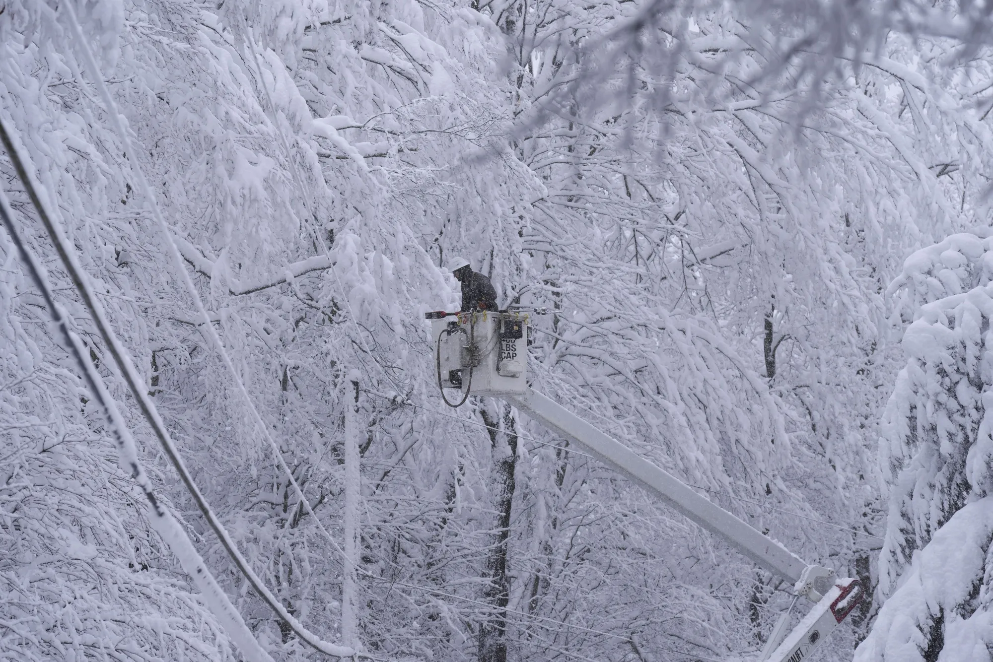 A worker repairs power lines covered in snow in Moscow, Pennsylvania.